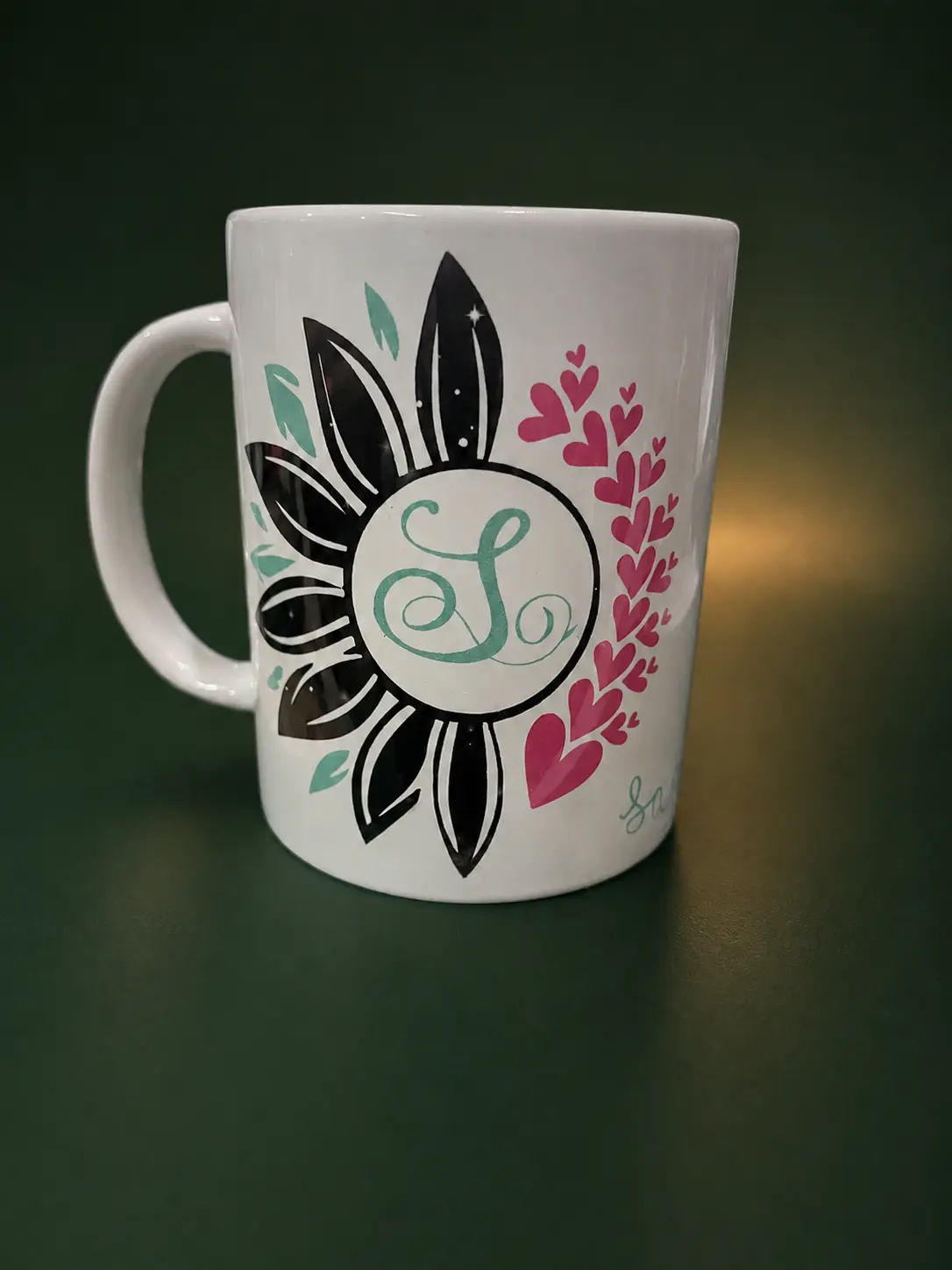 Tasse blanche décorée d’un motif floral et d’un monogramme